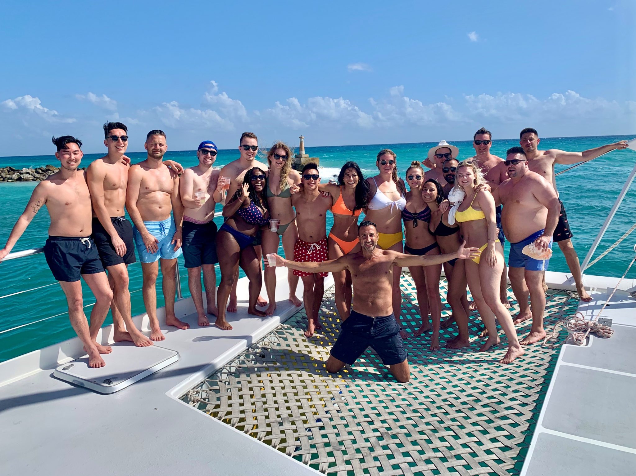 A group of ITIQ employees pose for a photo aboard a luxury catamaran boat